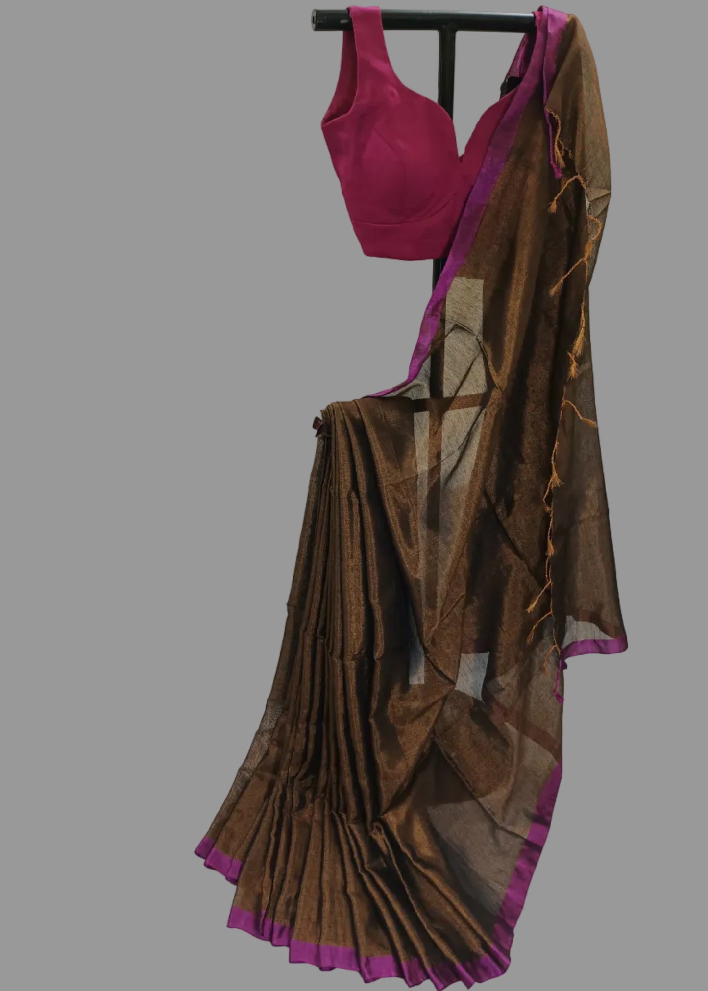 Brown saree with pink border draped over a mannequin against a white background