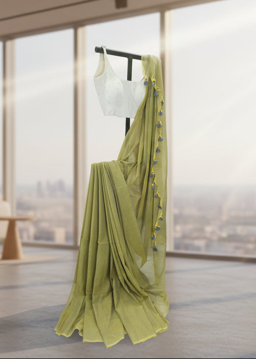 Green mul cotton saree with a blurred cityscape in the background