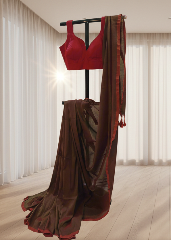 Red blouse and brown mu cotton saree on a stand against a neutral background