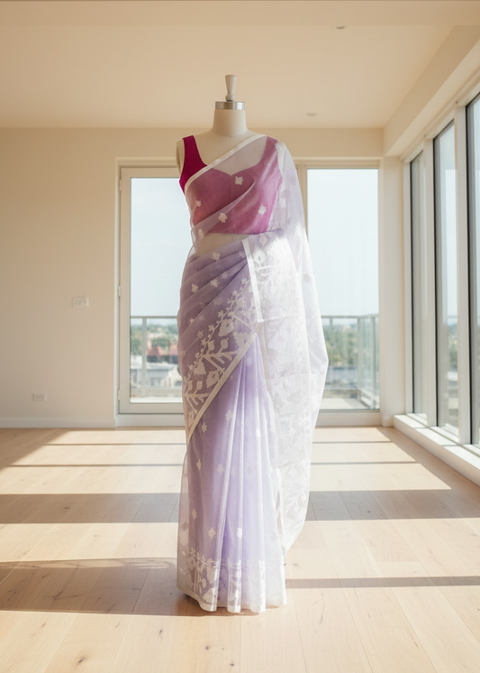 lavender jamdani saree with pink blouse on a mannequin in a bright room with large windows.