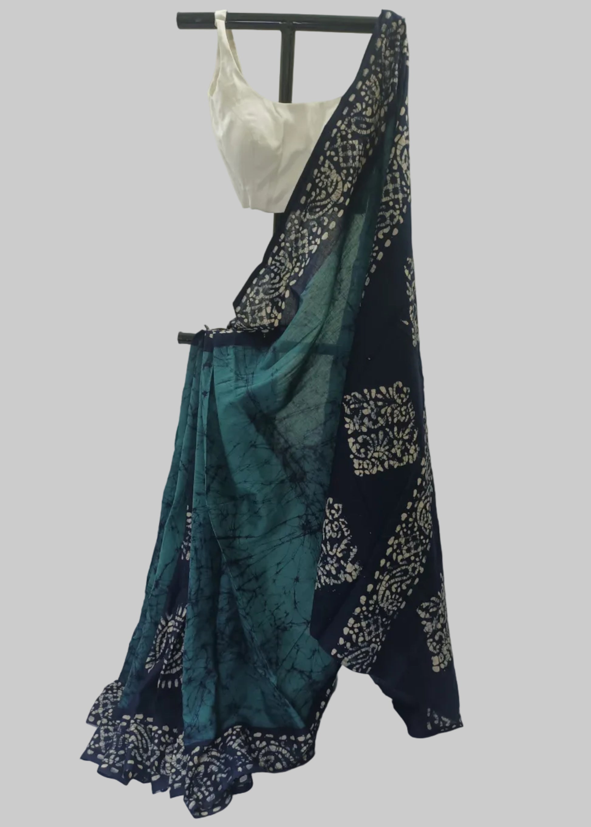 Teal and navy saree with white patterns on a white background