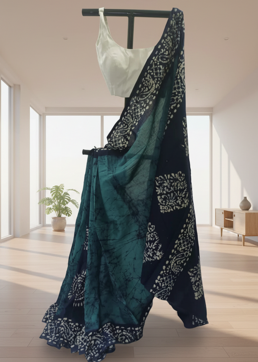 Teal saree with white patterns on a black rod against a neutral background