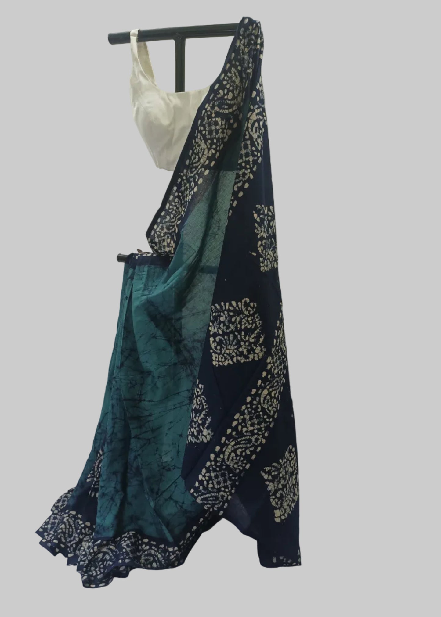 Navy and teal saree with white patterns draped over a mannequin against a plain background