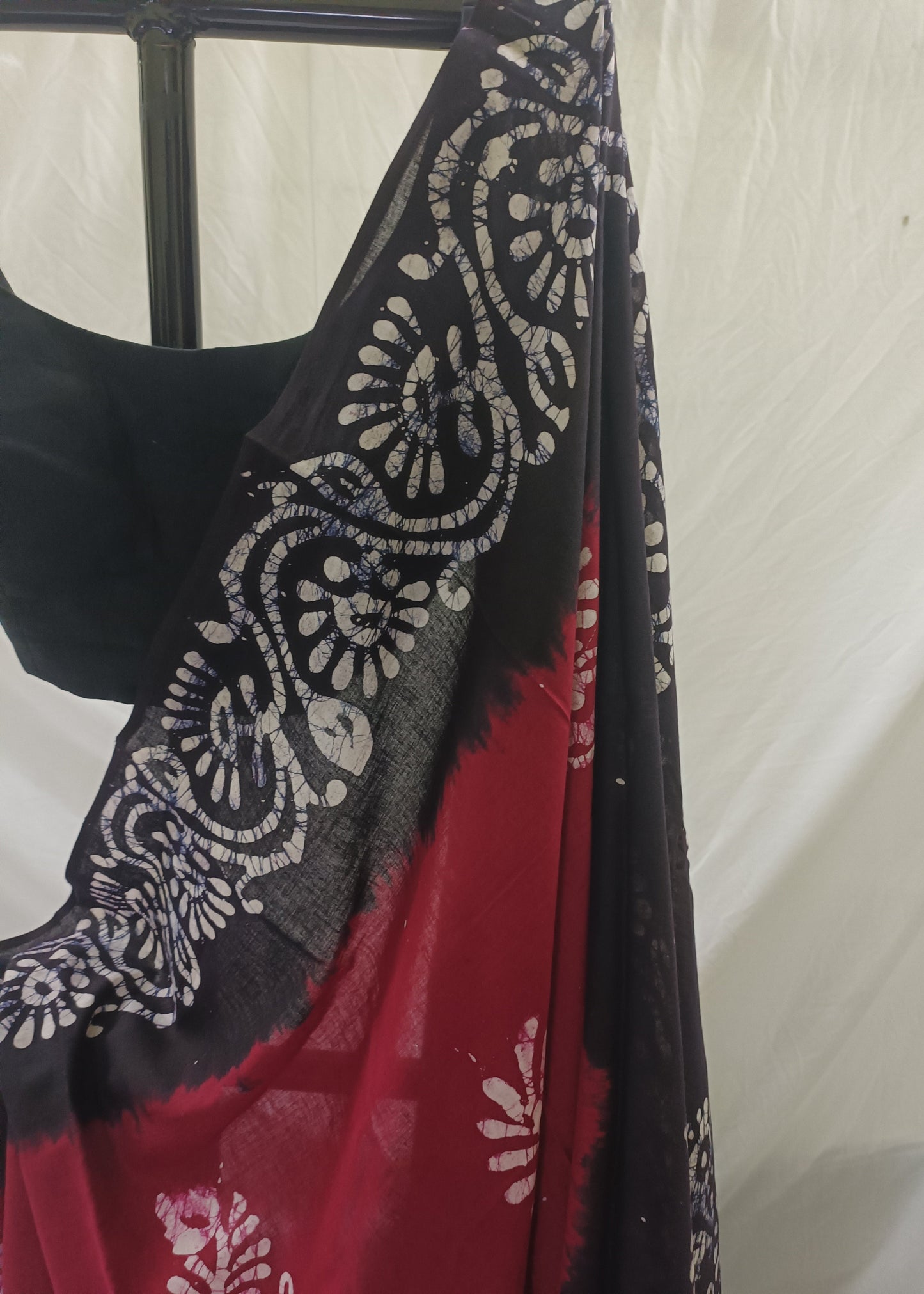 Black and red patterned fabric draped over a mannequin against a white background