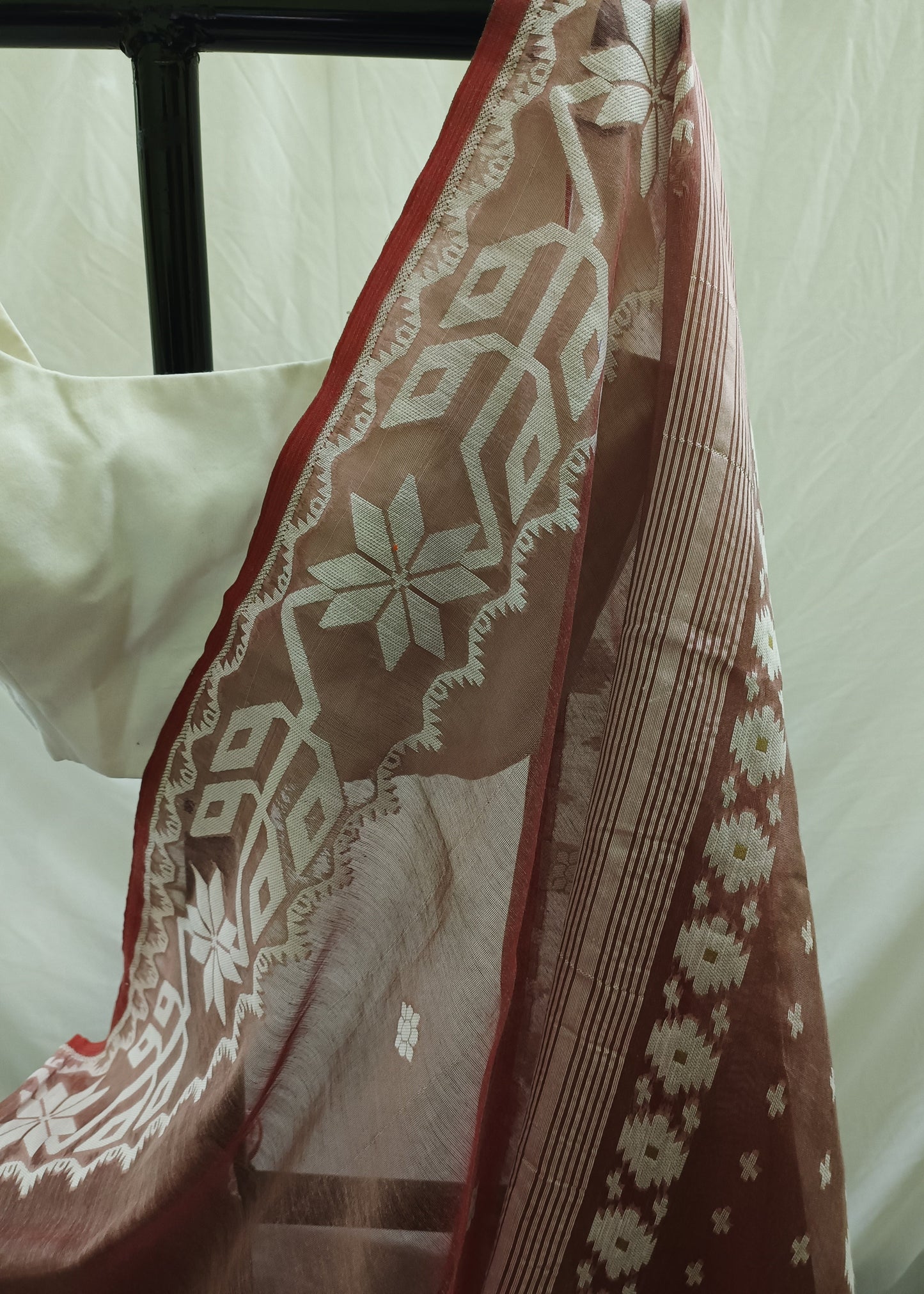 Close-up of a brown fabric with white floral patterns on a white background