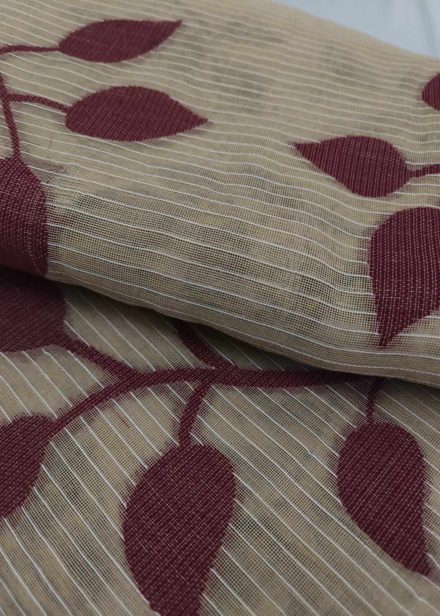 Close-up of fabric with red leaf pattern on beige background