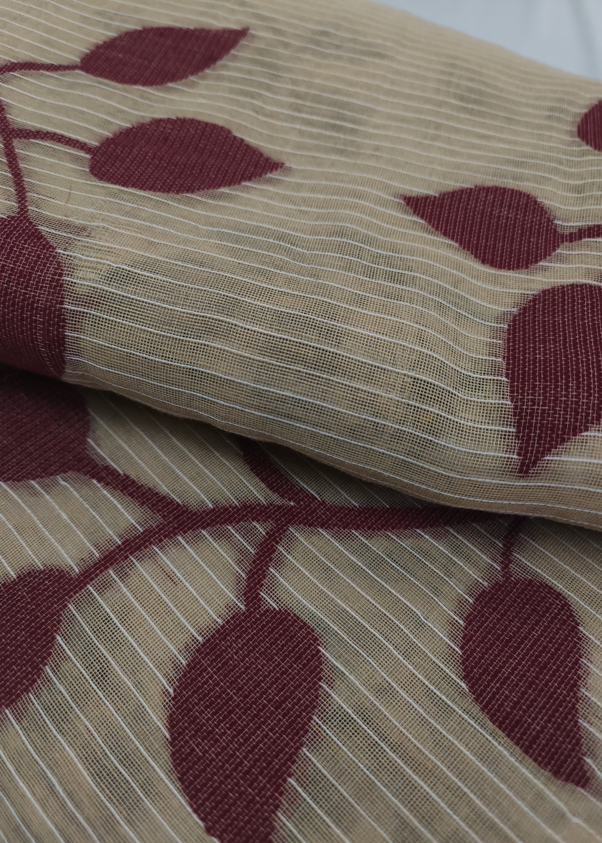 Close-up of fabric with red leaf pattern on beige background