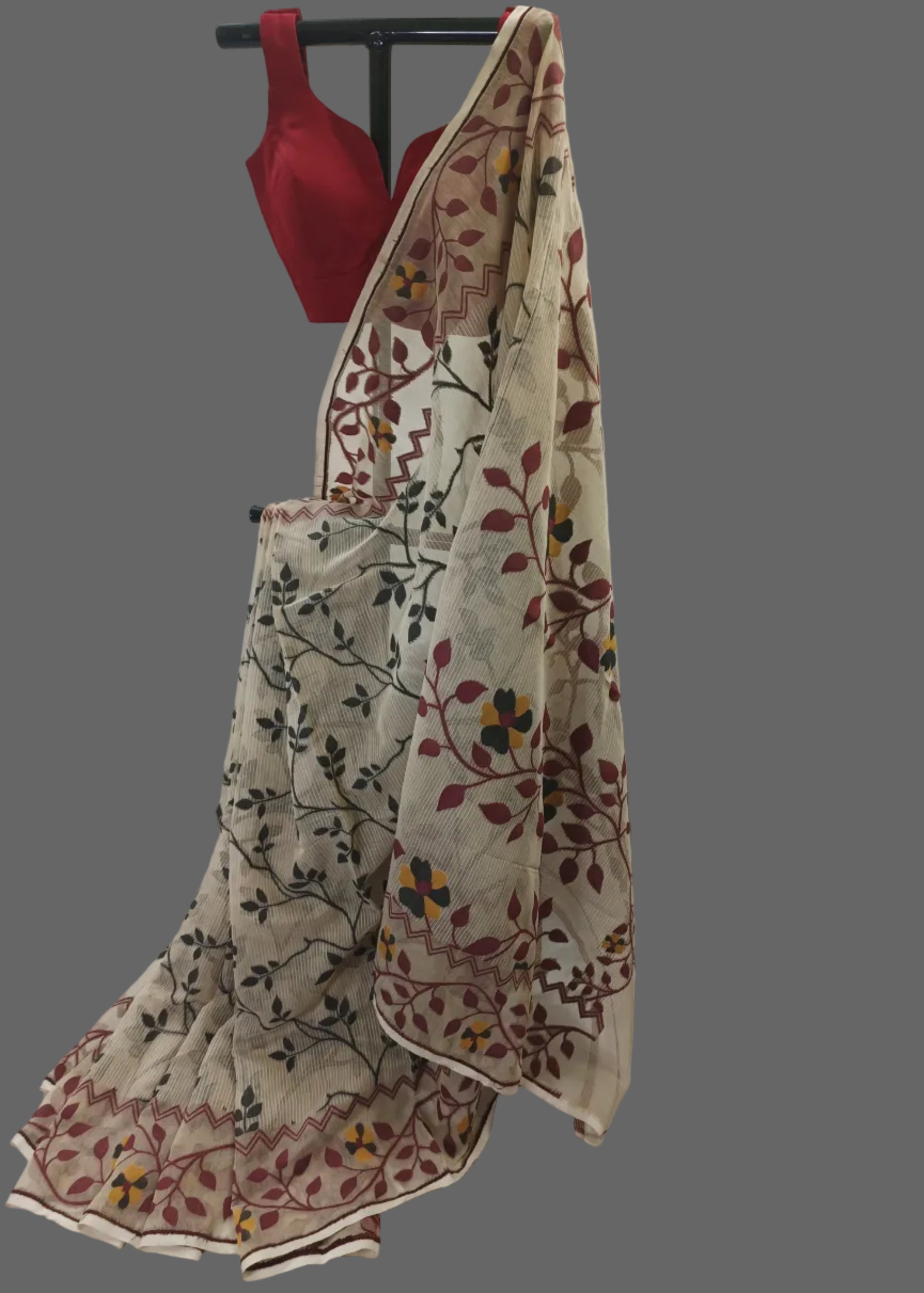 Beige saree with floral patterns draped over a white fabric backdrop