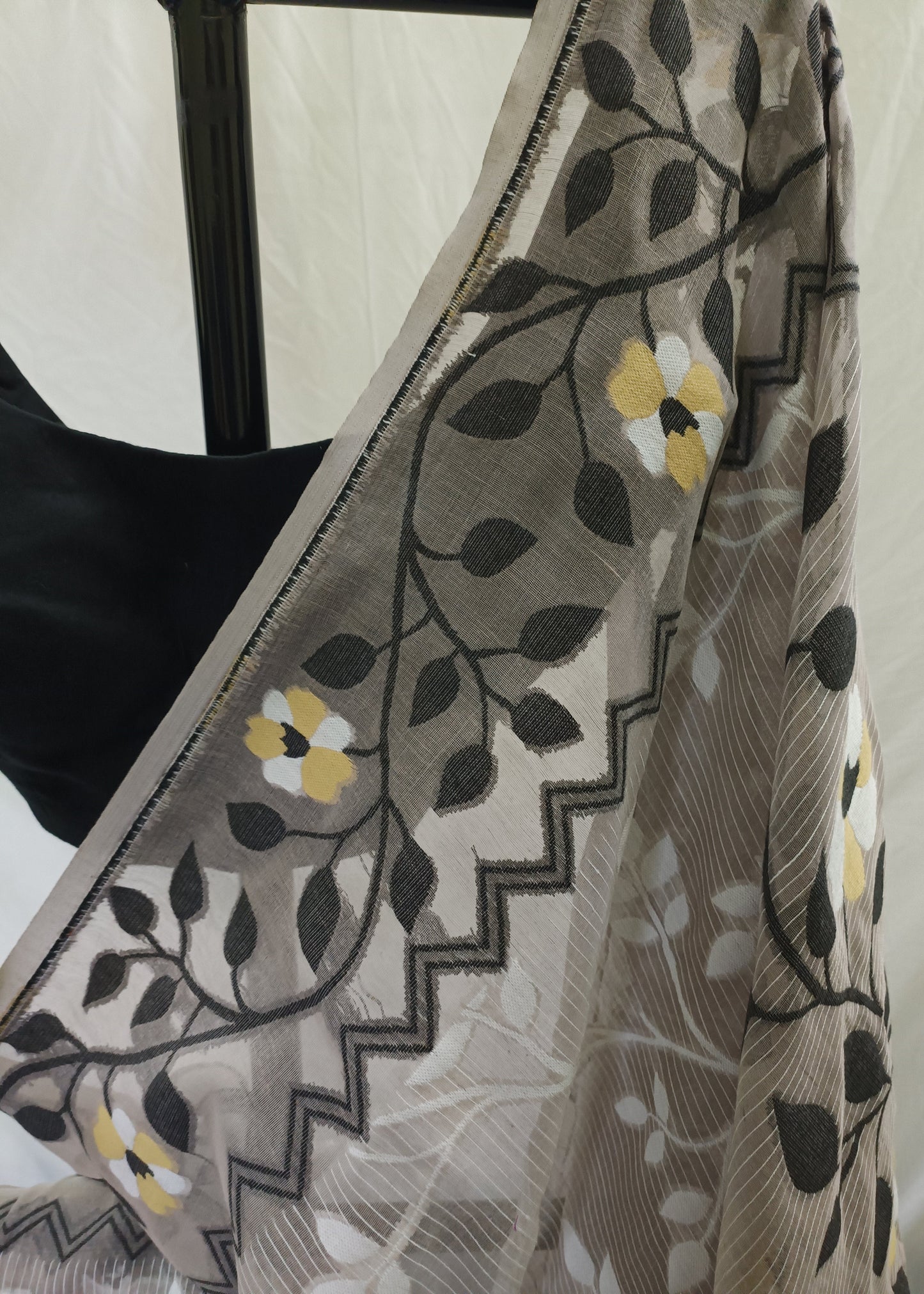 Close-up of a floral patterned fabric with black, yellow, and white colors.