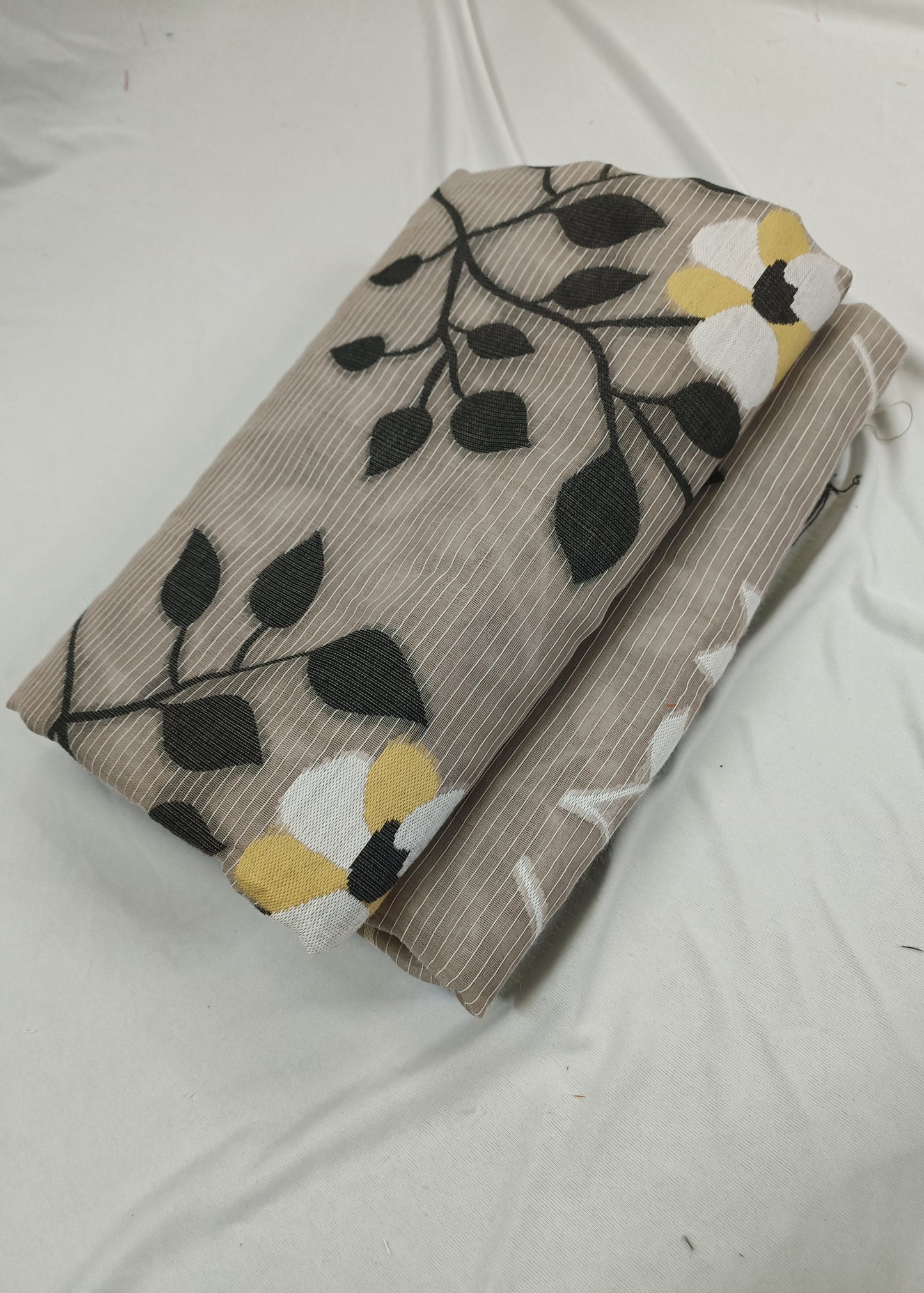 Folded fabric with leaf pattern on a white background