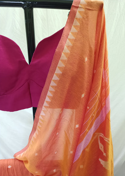 Orange fabric with white patterns draped over a pink garment on a white background