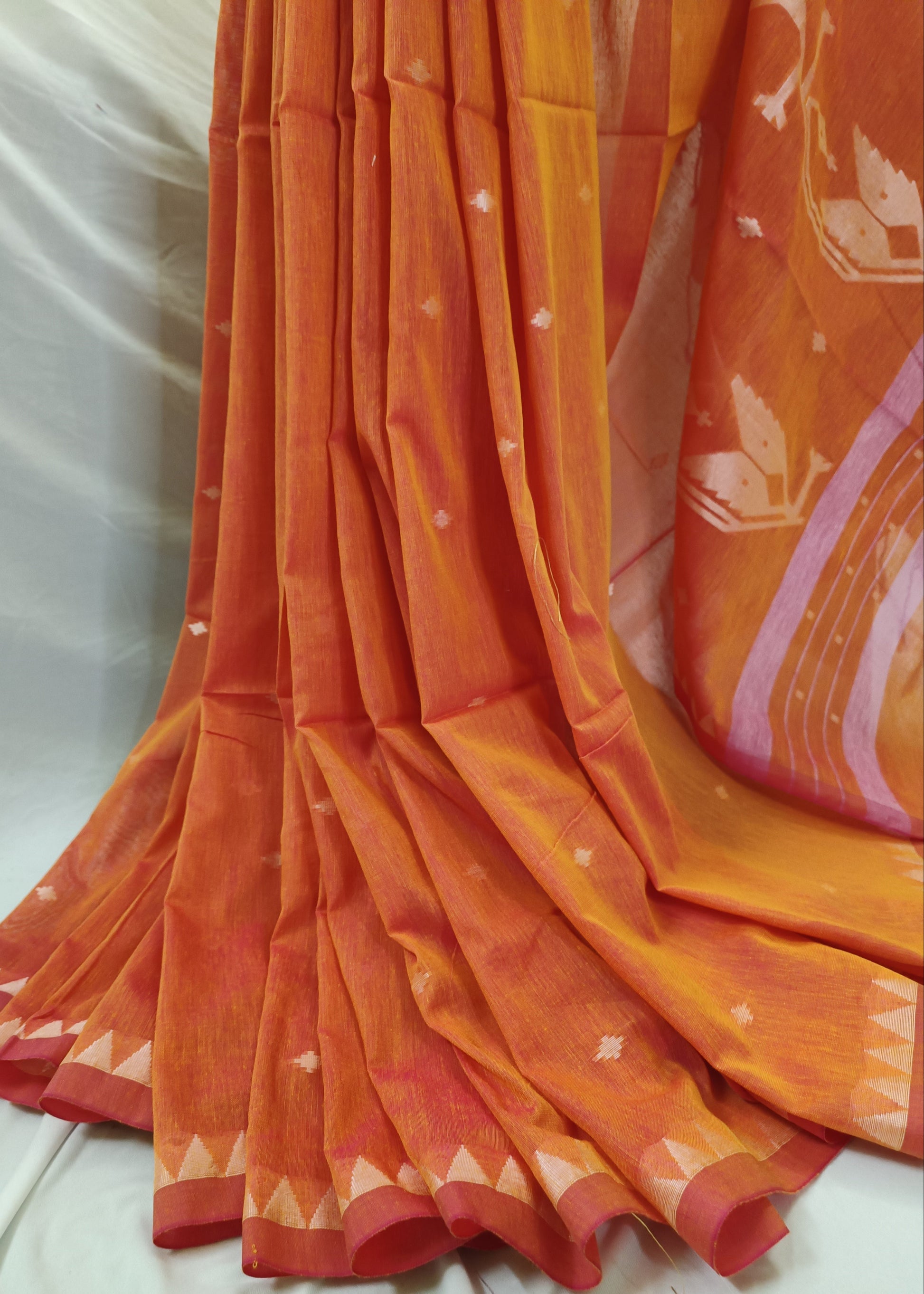 Orange saree with white patterns on a white background