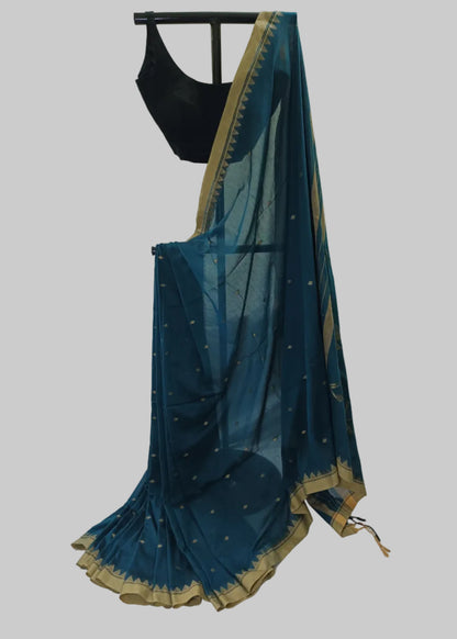 Blue saree with gold border draped over a white fabric background