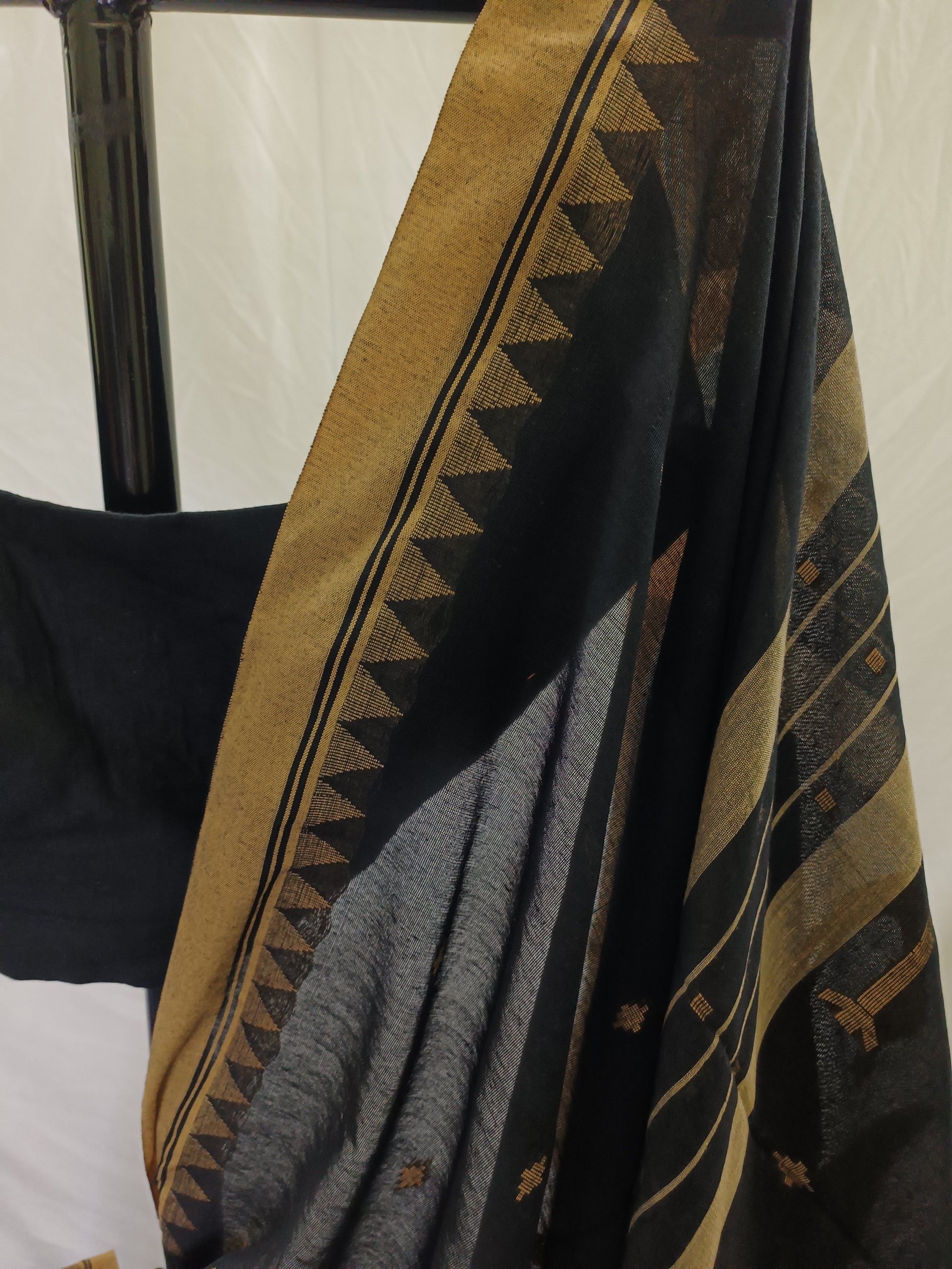 Textile with geometric pattern draped over a chair against a white background