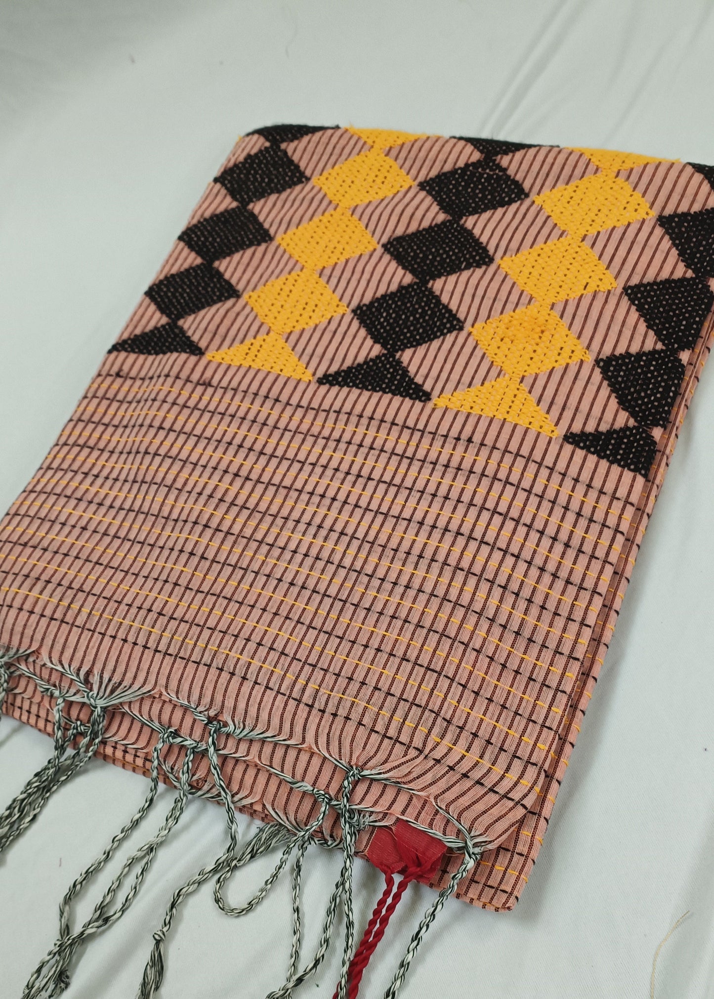 Woven blanket with geometric pattern and tassels on a white background