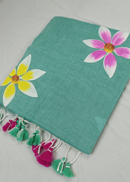 Turquoise fabric with floral designs and tassels on a light gray background