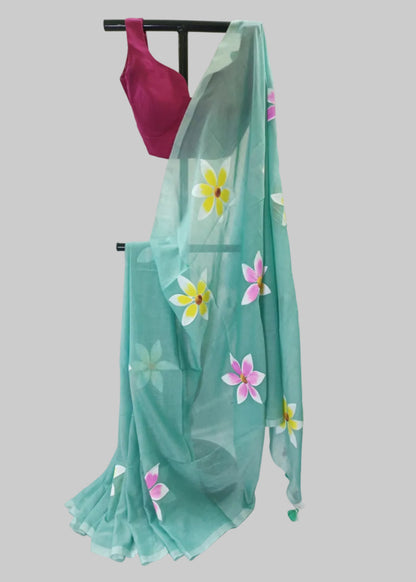 Teal saree with floral patterns draped over a stand against a white background