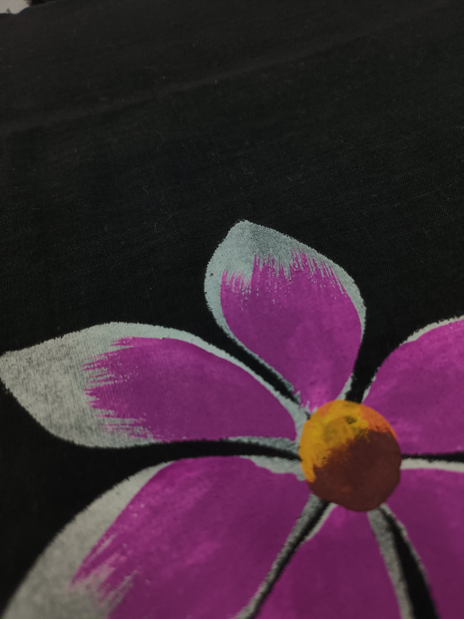 Close-up of a purple flower with a yellow center on a black background