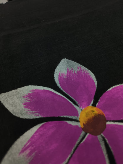 Close-up of a purple flower with a yellow center on a black background