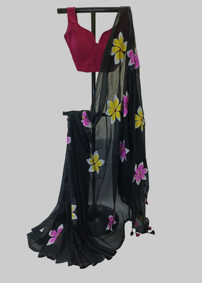 Black saree with floral patterns draped over a stand against a white background