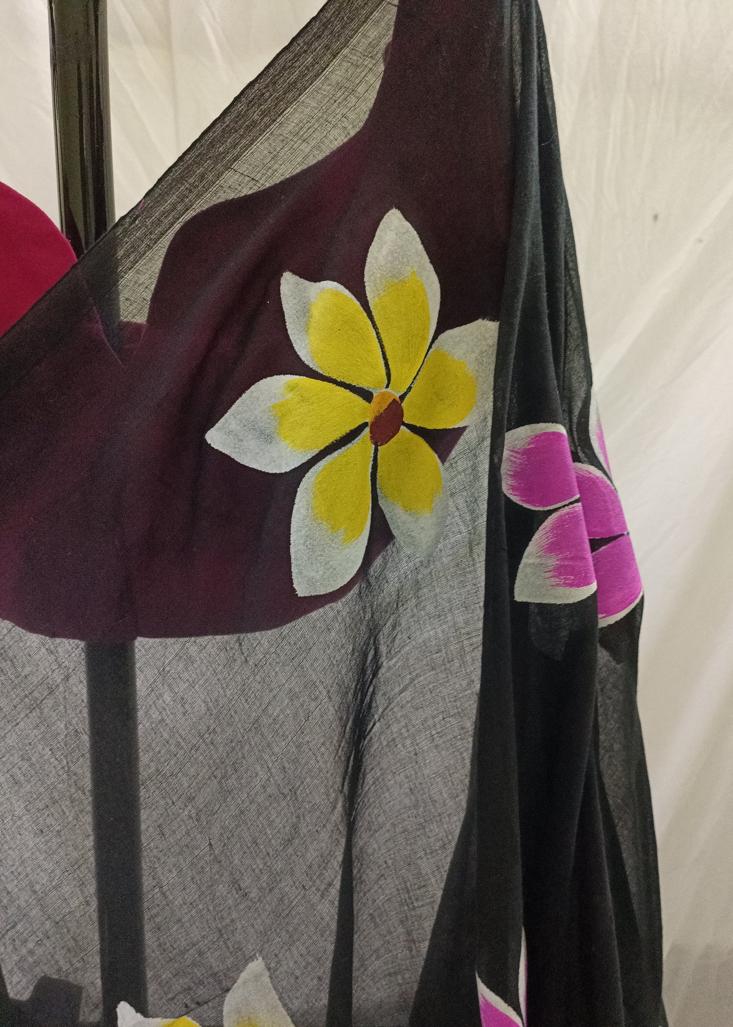 Black fabric with colorful flower designs on a plain background