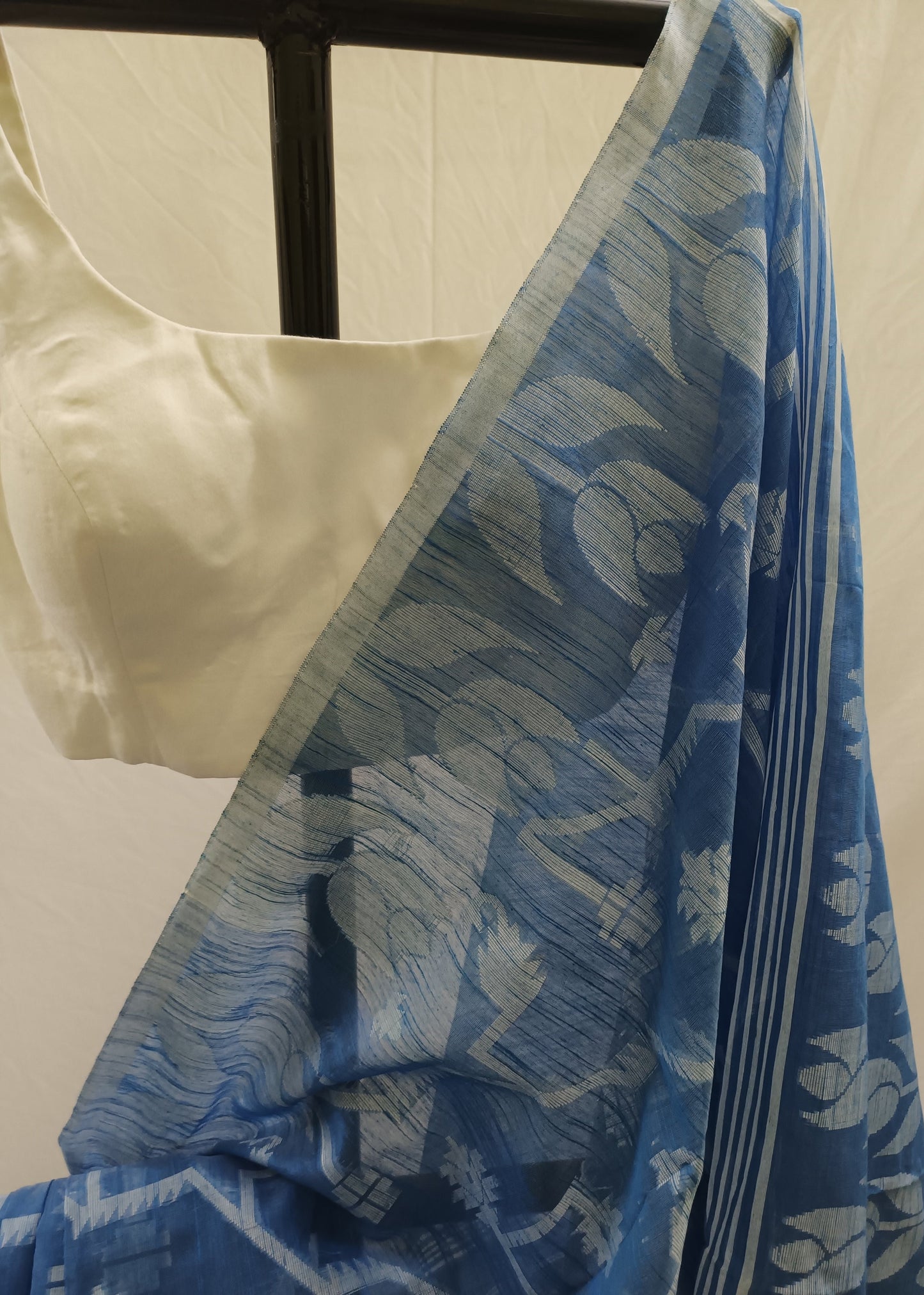 Blue floral patterned fabric draped over a mannequin with a white background