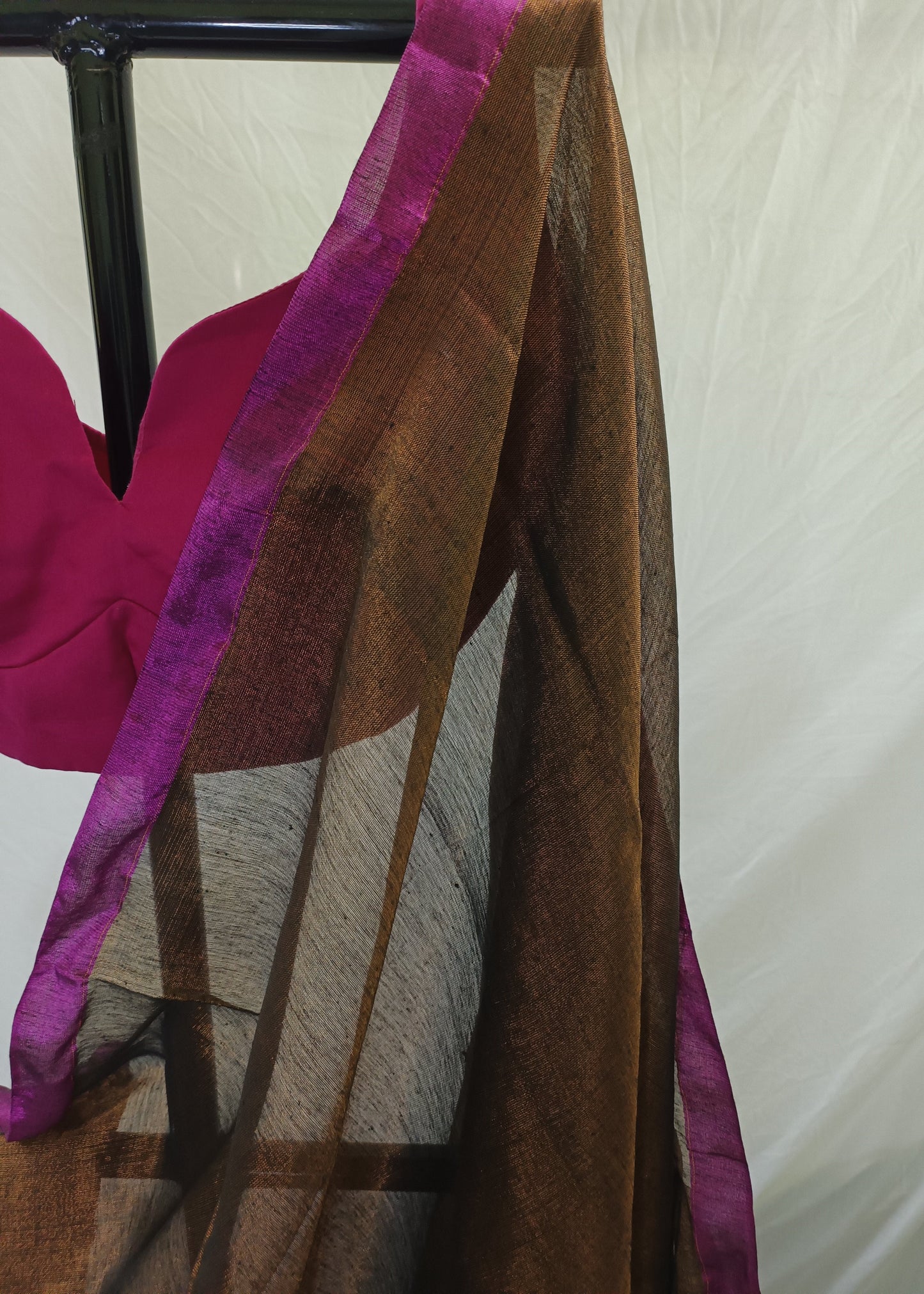 Brown fabric with purple trim draped over a chair against a neutral background