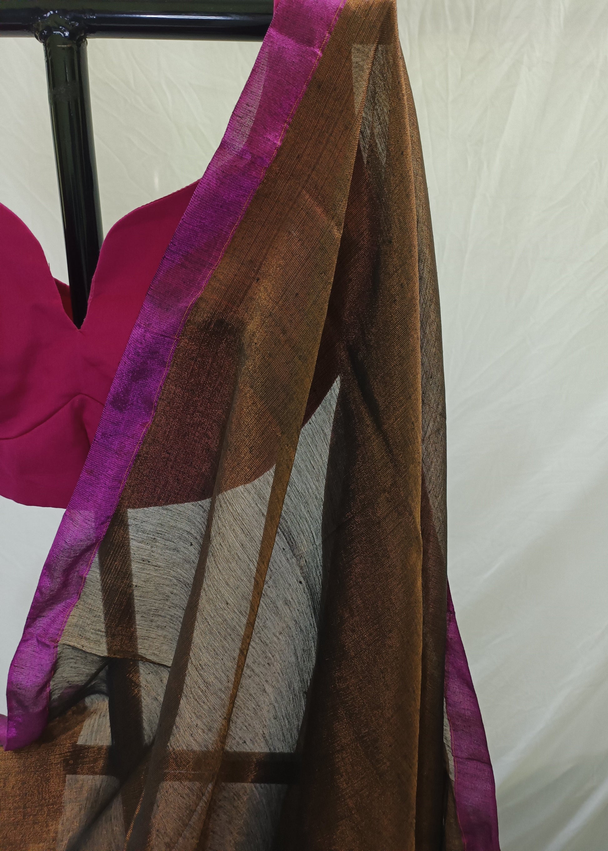 Brown fabric with purple trim draped over a chair against a neutral background