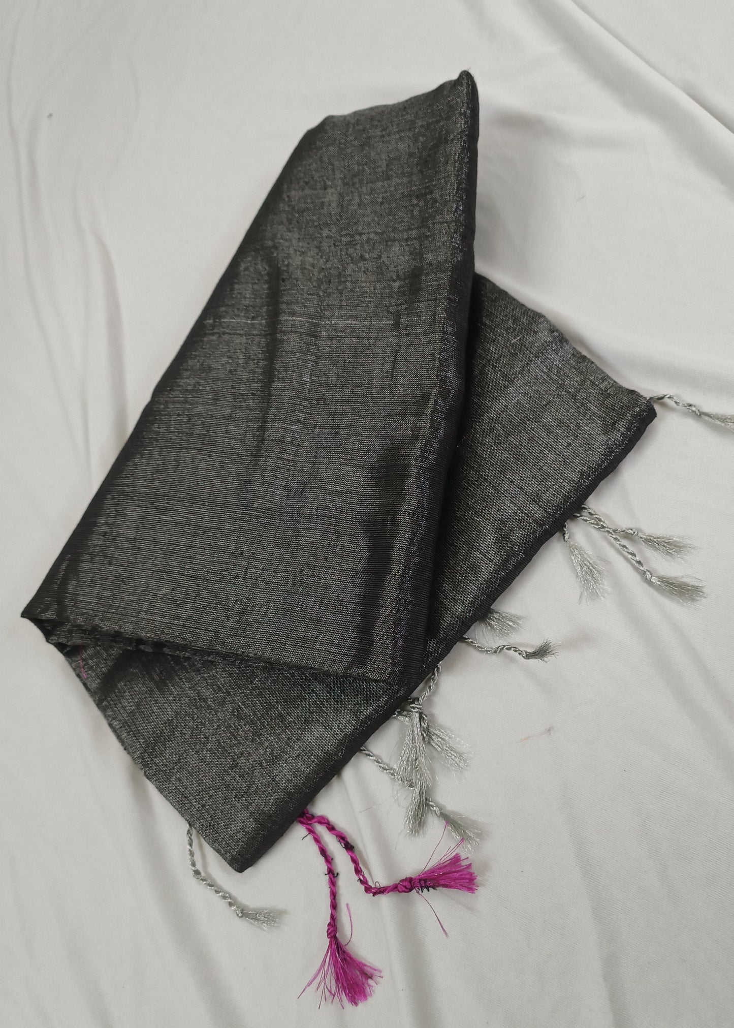 Dark gray fabric with tassels on a light background