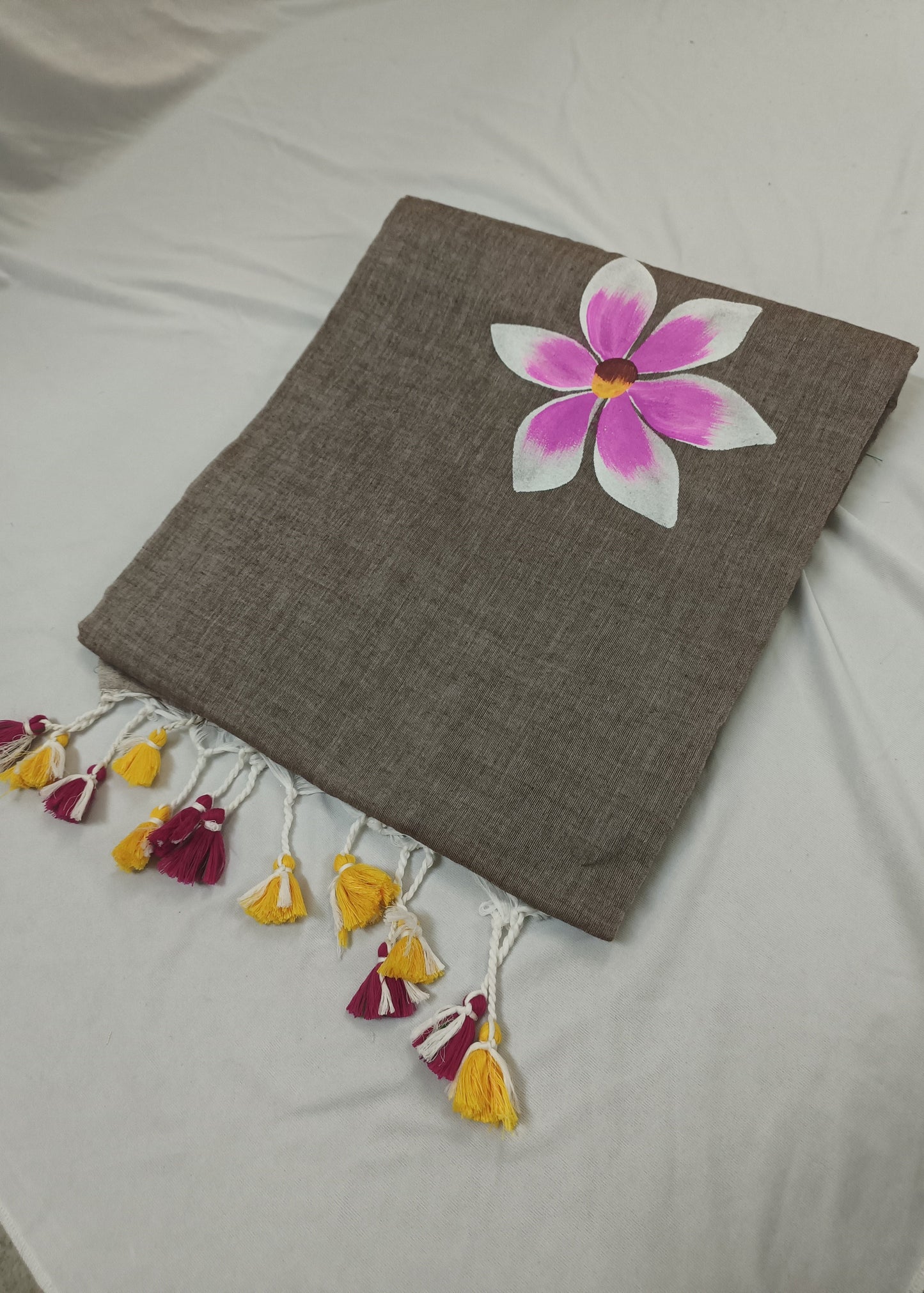 Brown saree with a pink flower design on a white background