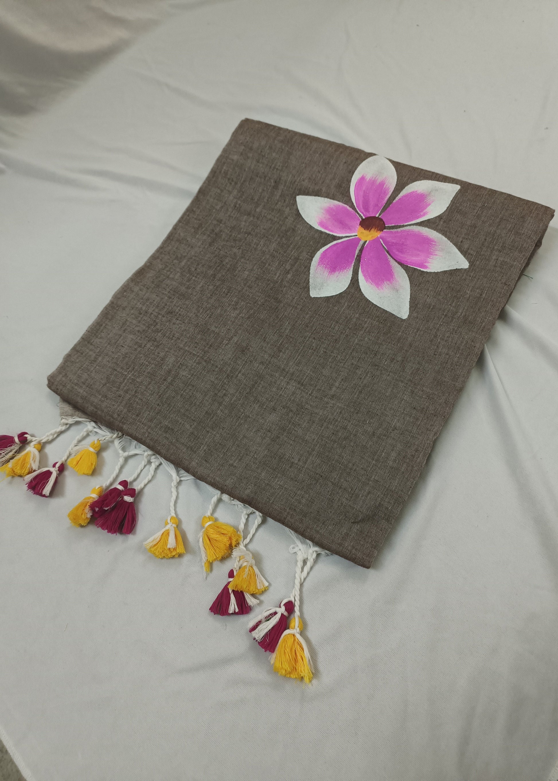 Brown saree with a pink flower design on a white background