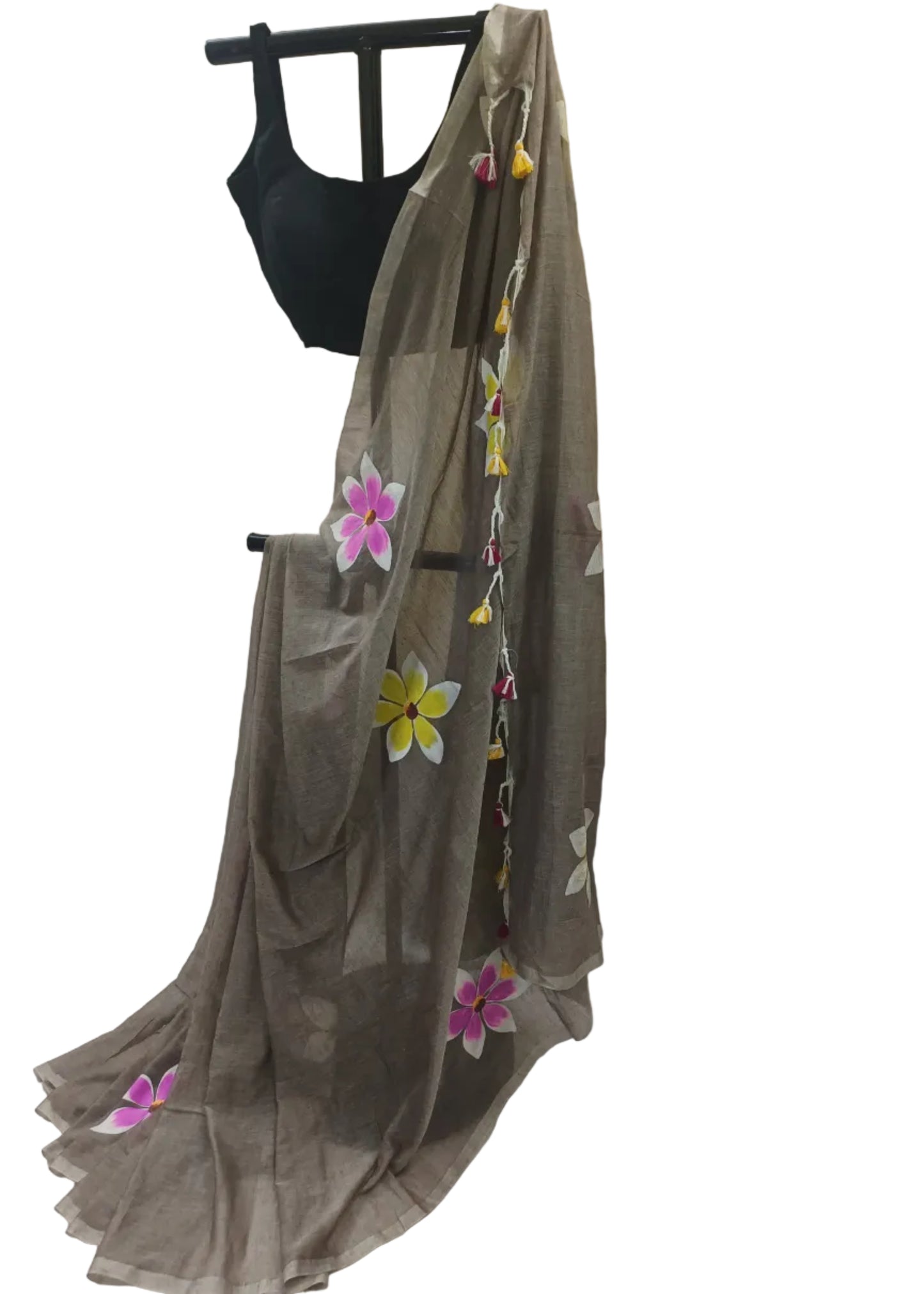 Brown saree with floral decorations on a mannequin against a plain background