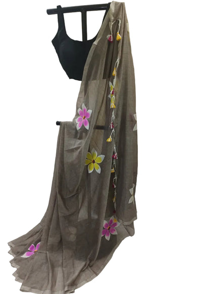 Brown saree with floral decorations on a mannequin against a plain background