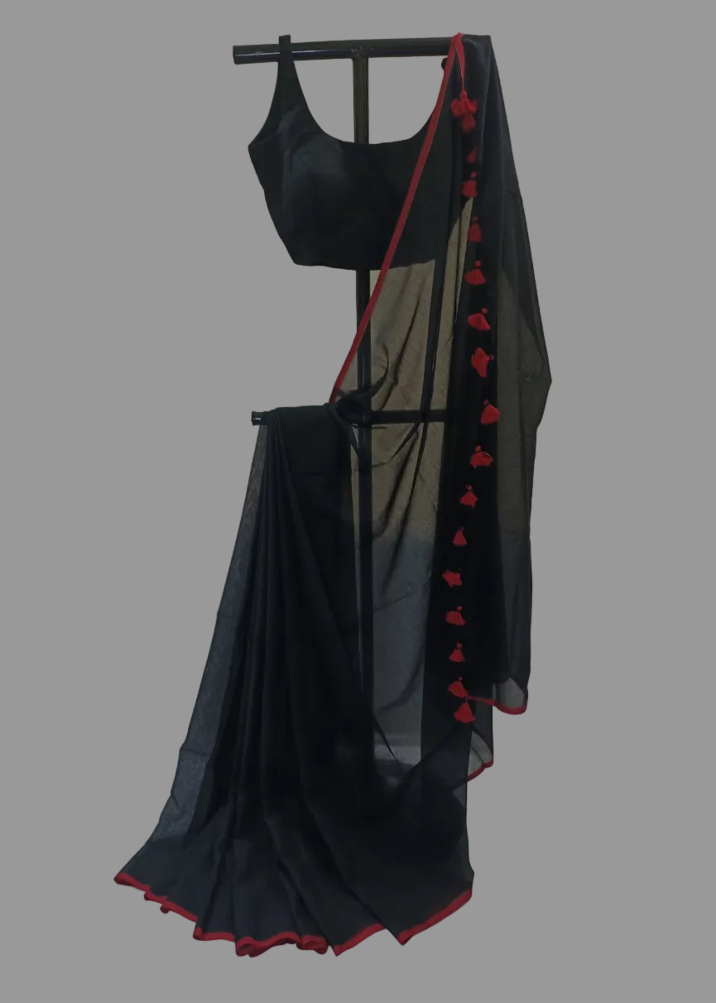 Black saree with red accents on a mannequin against a plain background