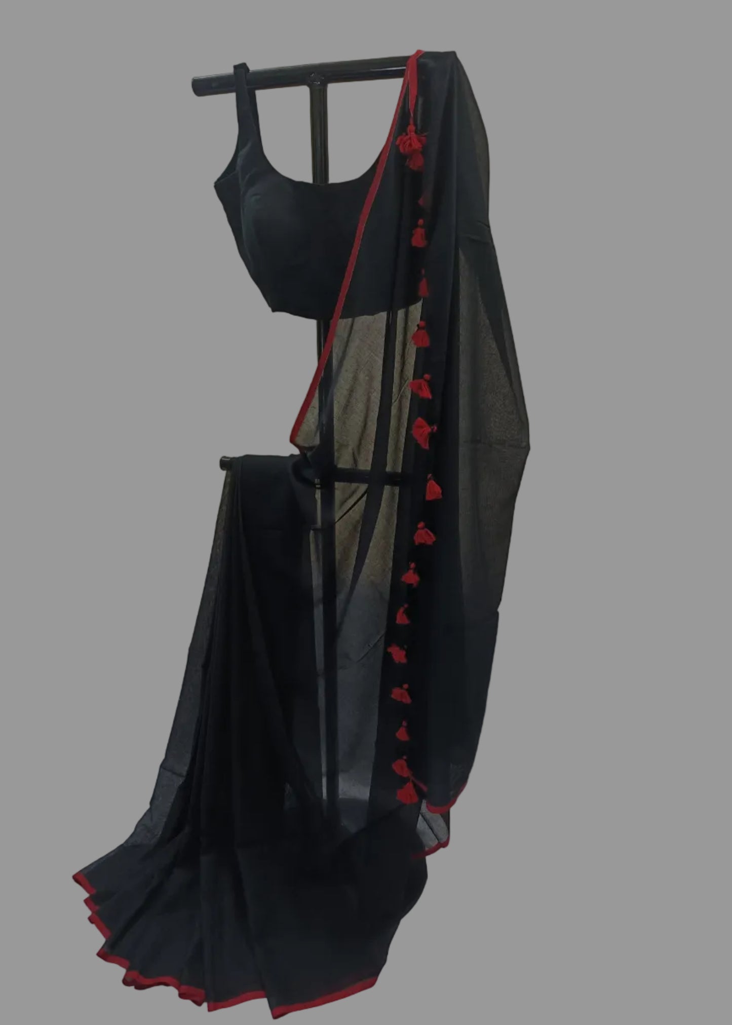 Black saree with red border on a white background