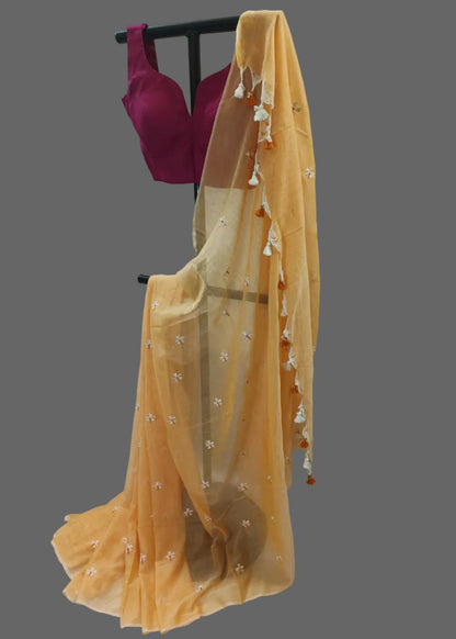 Yellow saree with a purple blouse on a mannequin against a white background