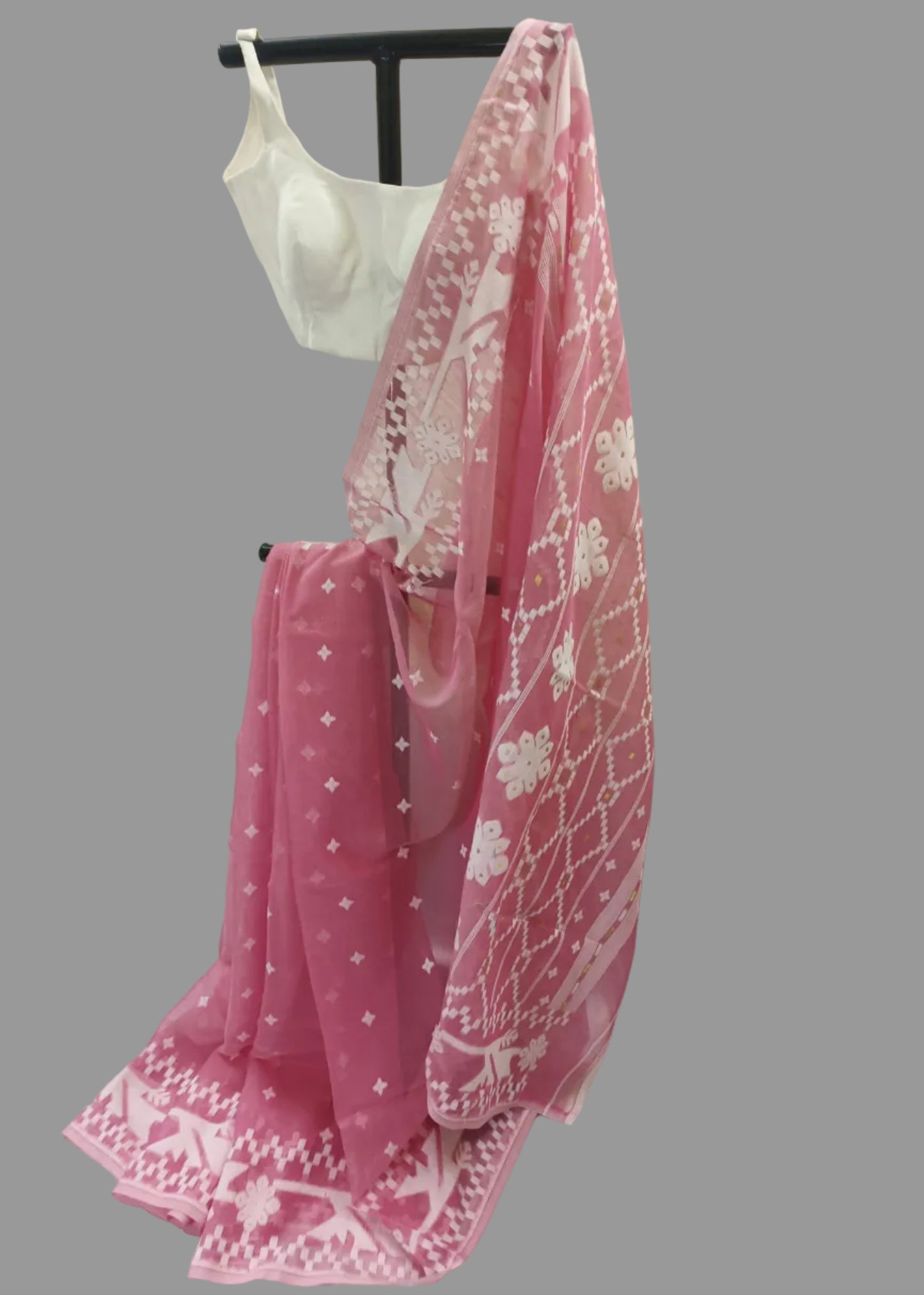 Pink saree with white patterns on a mannequin against a plain background