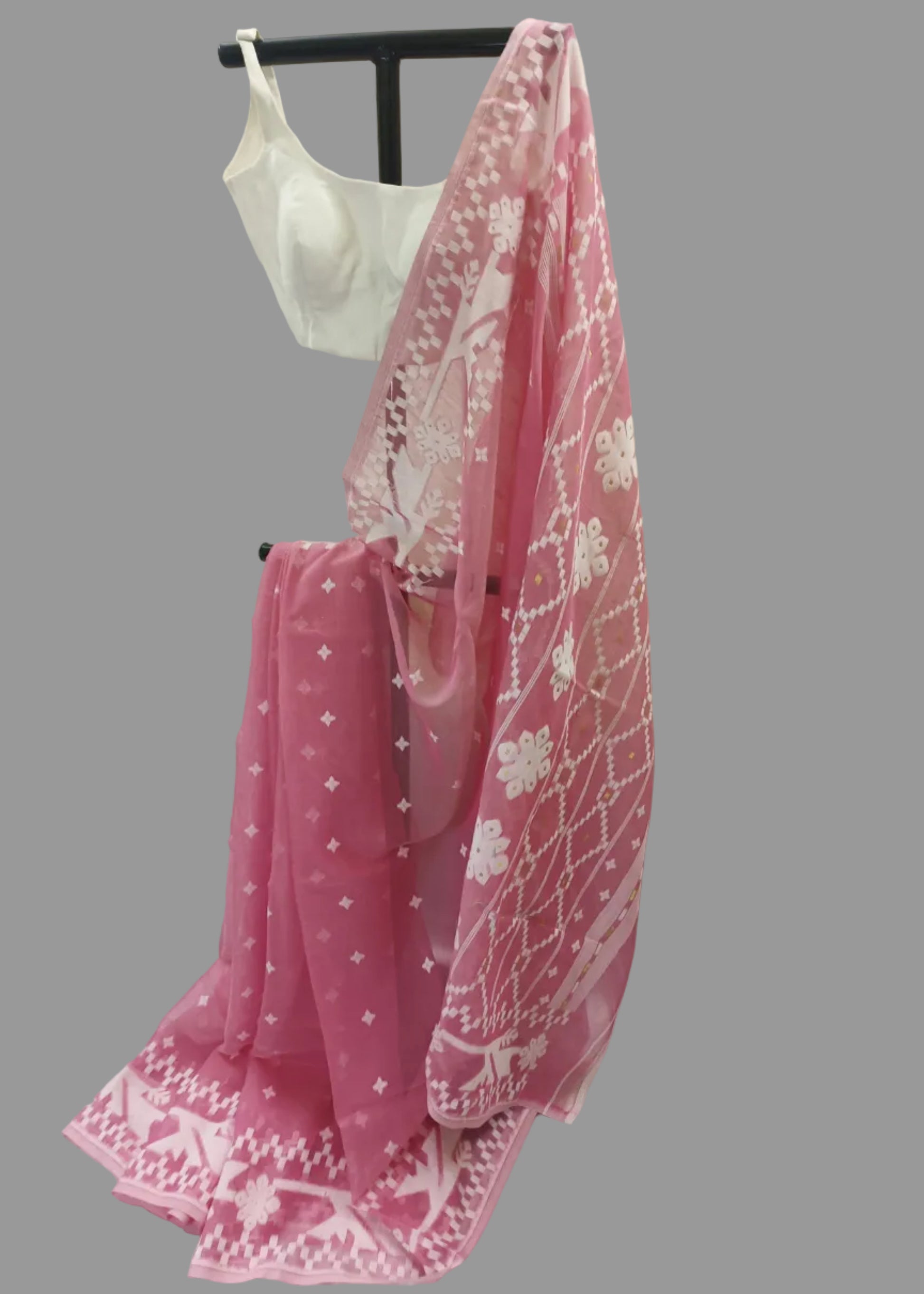 Pink saree with white patterns on a mannequin against a plain background