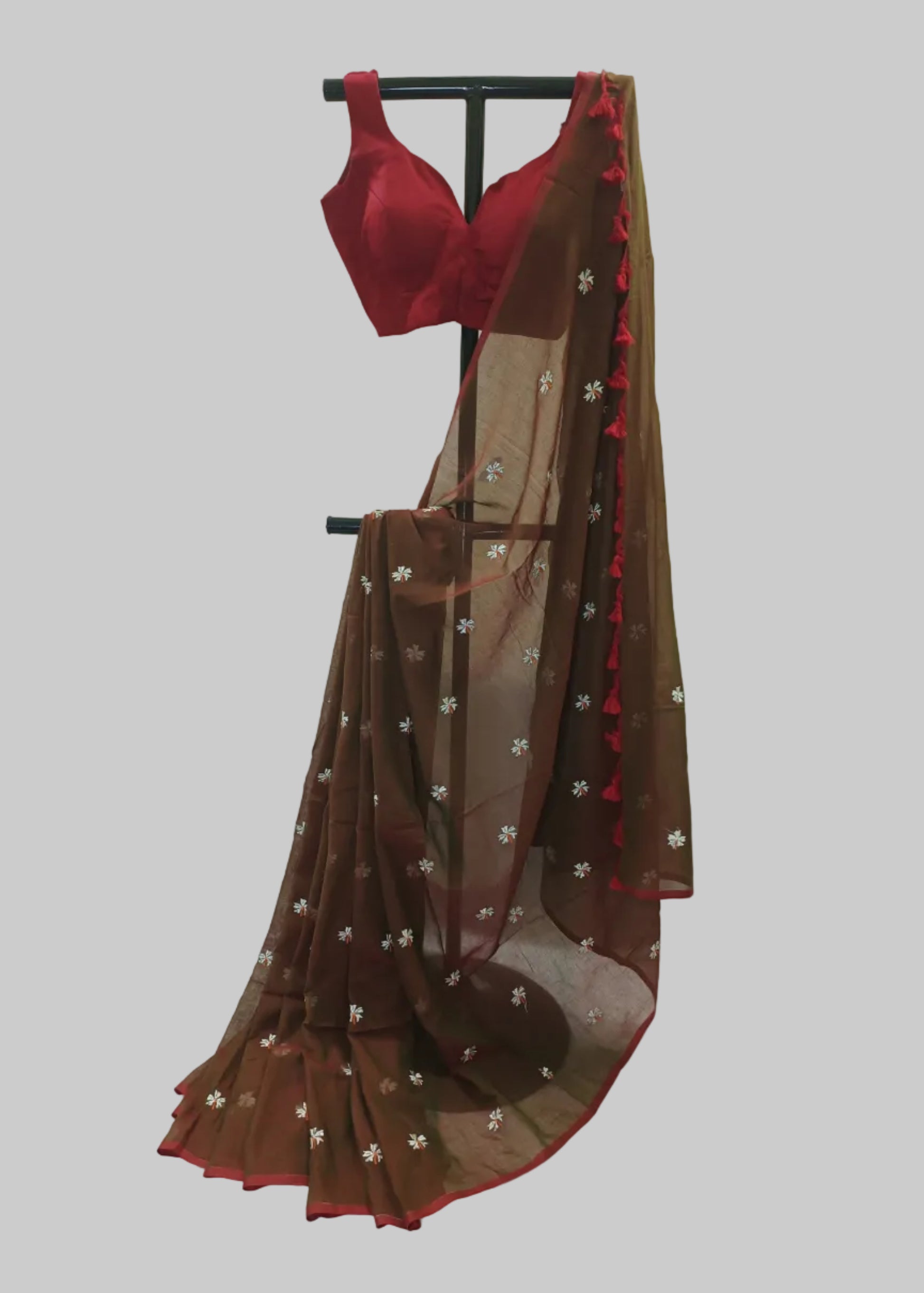 Red blouse and brown saree with floral patterns on a white background
