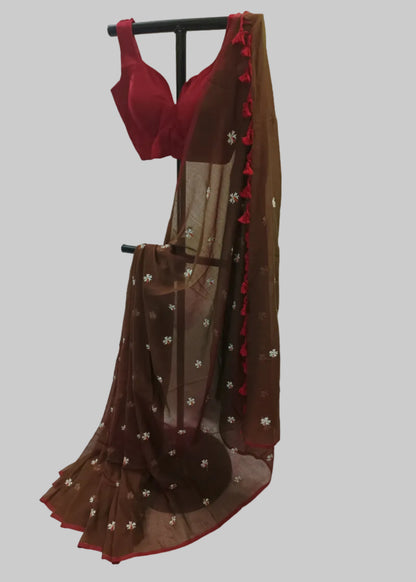 Brown saree with red border and red blouse on a white background