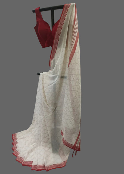 White saree with red border and red bra on a stand against a white background