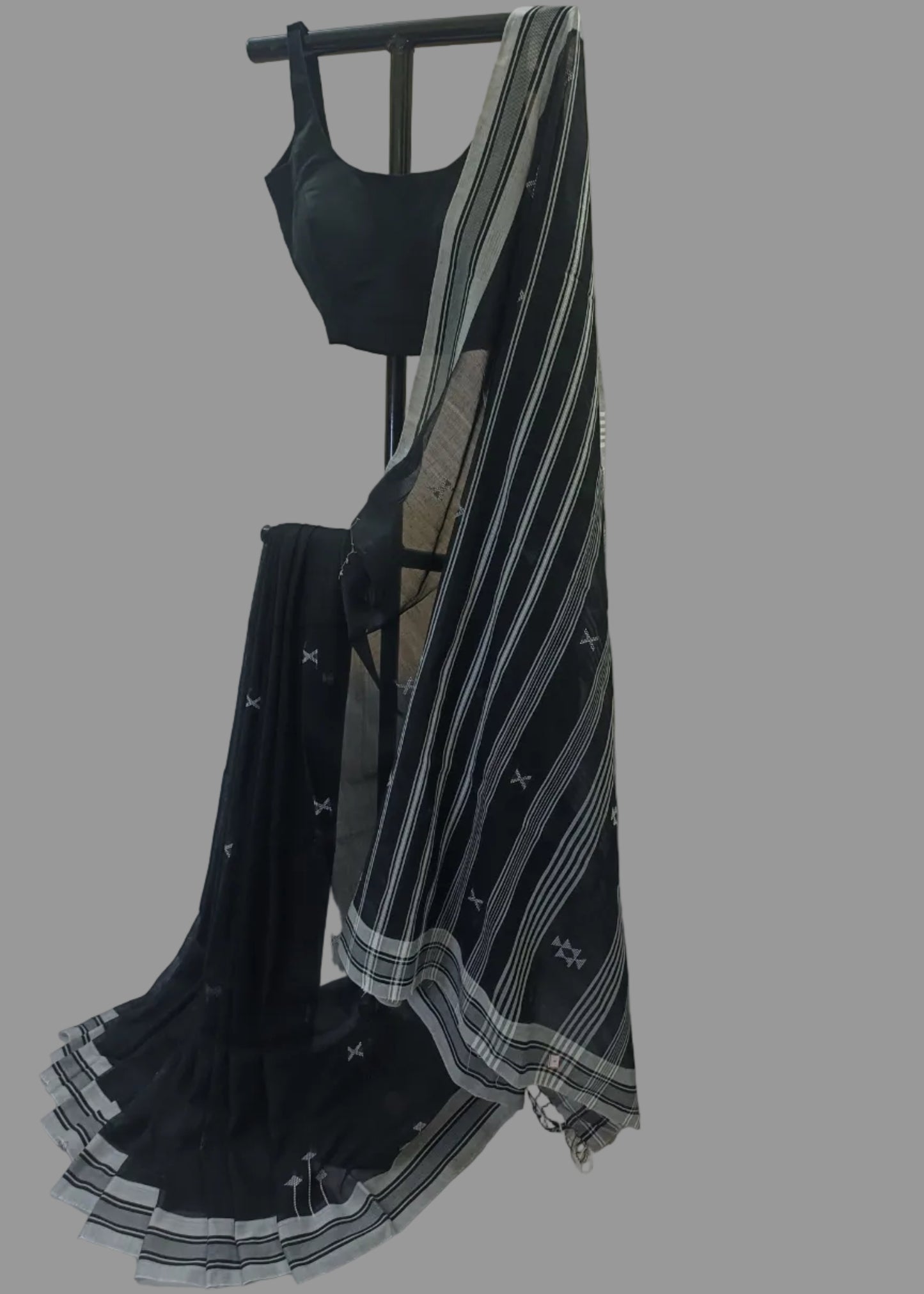 Black saree with white patterns on a mannequin against a neutral background
