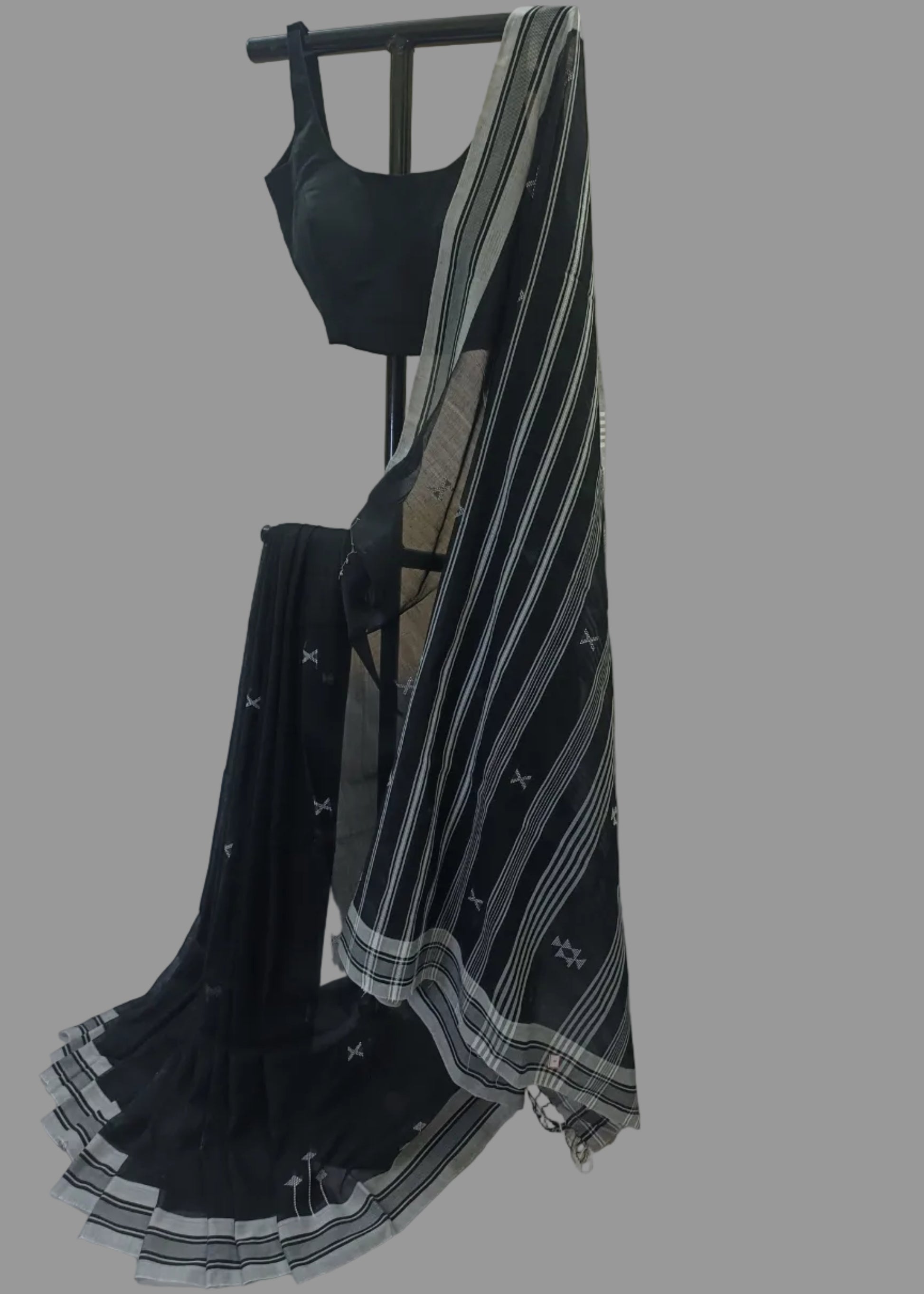 Black saree with white patterns on a mannequin against a neutral background