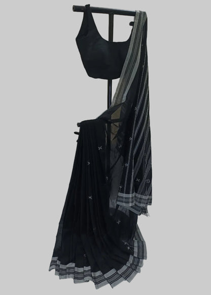 Black saree with white patterns on a stand against a neutral background