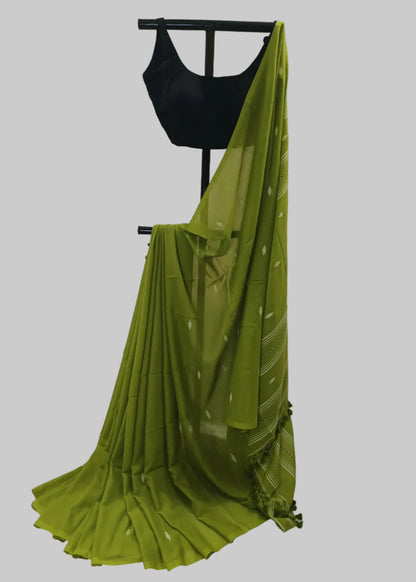 Green saree with a black blouse on a mannequin against a white background
