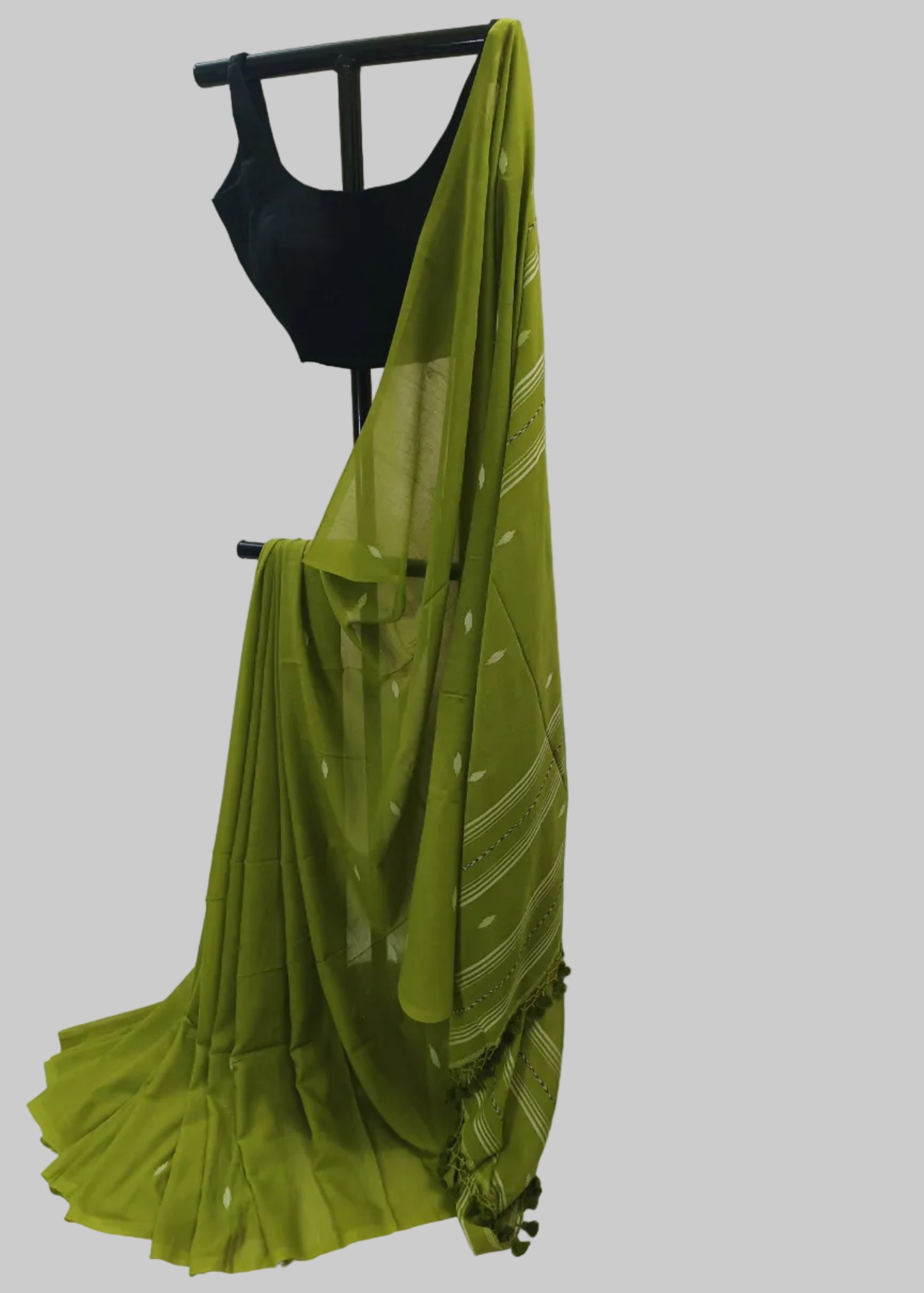 Green saree draped over a black blouse on a white background