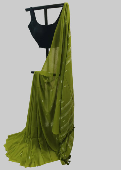 Green saree draped over a black blouse on a white background