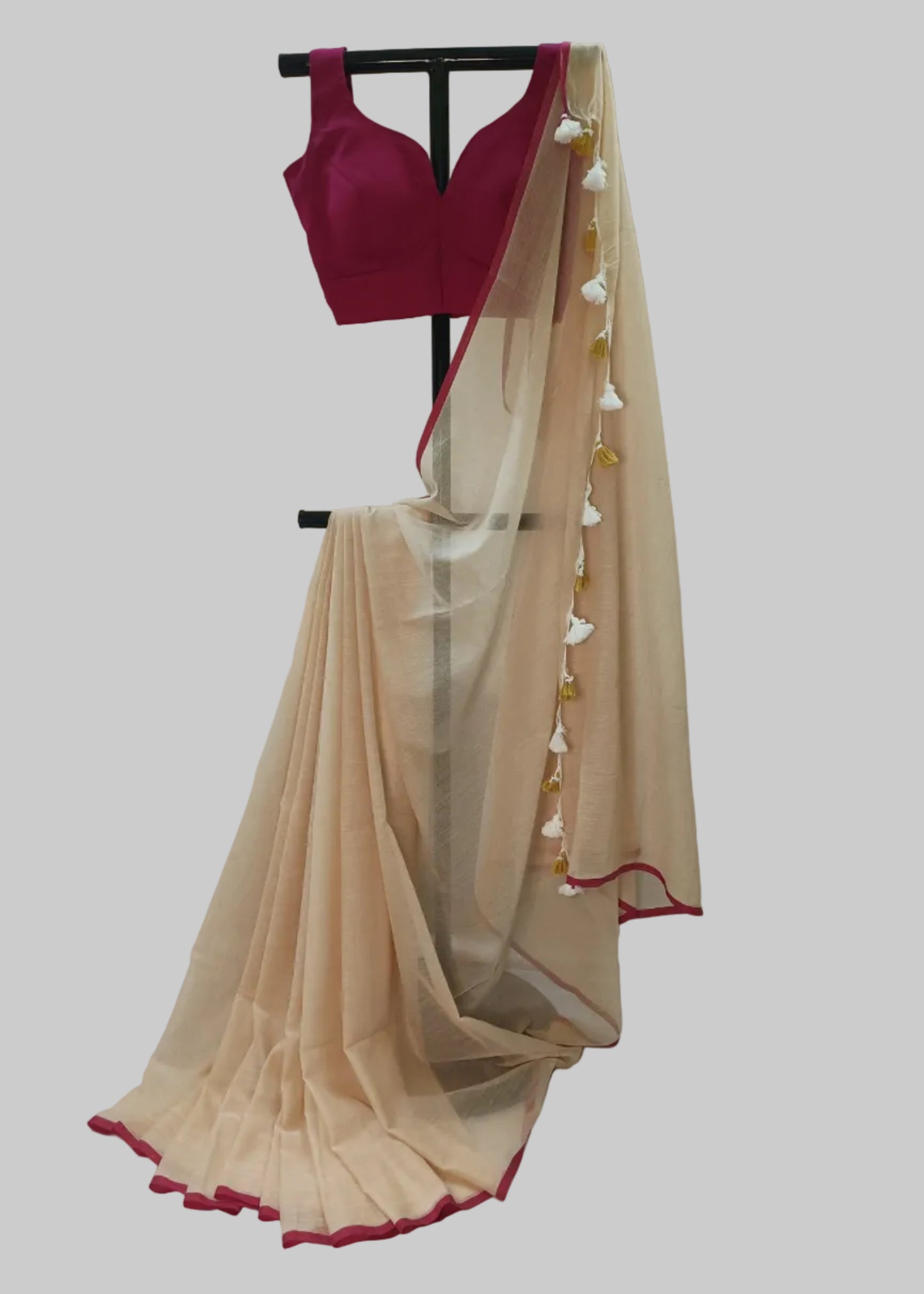 Pink blouse and beige saree with red border on a white background