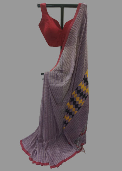 A purple and white checkered saree with a red border and a matching red blouse displayed on a black hanger against a white curtain backdrop.
