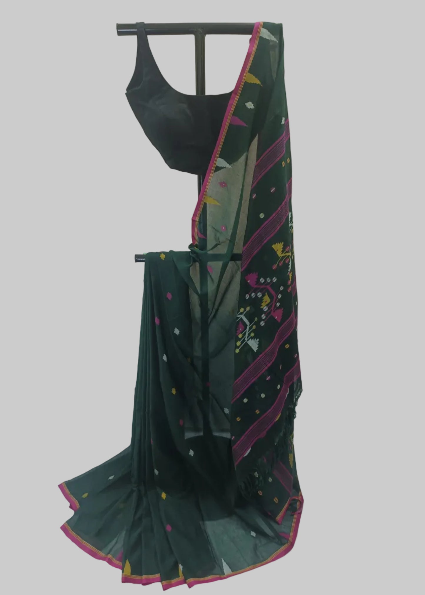A dark green saree with pink and multicolor geometric border patterns and a matching black blouse, displayed on a black hanger against a white fabric backdrop.